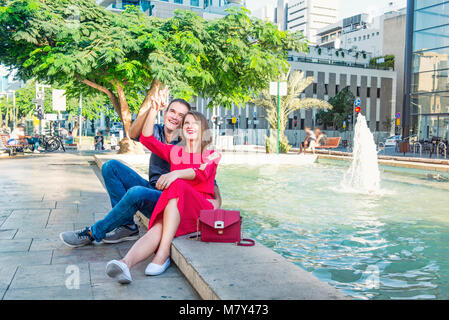 Romantisches Paar auf der Bank sitzen in der Nähe der Stadt Brunnen und genießen Sie Momente des Glücks. Liebe, Dating, Romantik. Lifestyle und Tourismus Konzepte. Stockfoto