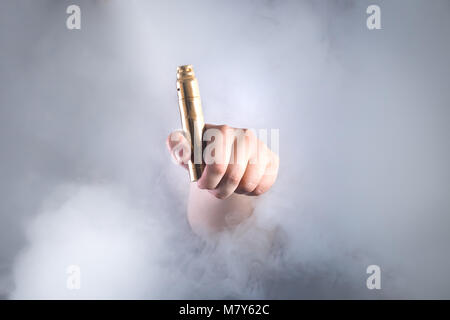 Mann hält vaping Gerät in Rauch. Alternative zum Rauchen von Zigaretten Stockfoto