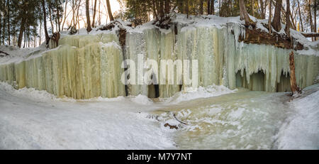 Eben Eishöhlen in Michigan's Upper Peninsula über einen Felsvorsprung, wie ein Wasserfall, Erstellen von gemusterten Vorhängen, Eis in der Nähe von Mühlbach Kreuzung Michigan. Stockfoto