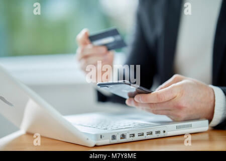 Mann mit Laptop holding Kreditkarte Stockfoto