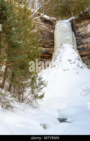 Munising fällt, ein Wasserfall in Munising Michigan solide im Winter friert, von Basalt und Sandsteinfelsen umgeben. Stockfoto