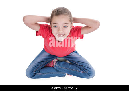 Junge schöne Mädchen sitzt im Schneidersitz und sieht in die Kamera, Ansicht von oben, auf weißem Hintergrund Stockfoto