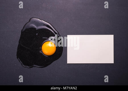 Ansicht von oben angeschlagene Eier auf den schwarzen Stein. Freier Platz für Text und Gestaltung Stockfoto