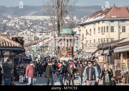 SARAJEVO, BOSNIEN UND HERZEGOWINA - 16. FEBRUAR 2018: die Tauben über die Bascarsija square Sebilj Brunnen fliegen. Bascarsija ist das Symbol von Sarajewo, Stockfoto