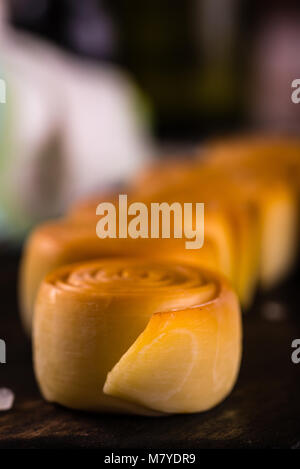 Vertikale Foto mit Details der traditionellen slowakischen Käse. Die parenica ist Streifen von geräucherter Käse gerollt in Zylinder Form. Paar Käse Brötchen sind pl Stockfoto