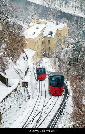 Rote Seilbahn Seilbahn auf Berg Schlossberg mit Blick auf verschneite Stadt Graz im Winter Stockfoto