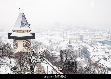 Schnee bedeckt Uhrturm Uhrturm Wahrzeichen auf Berg Schlossberg mit Luftaufnahme der Stadt Graz im Winter Stockfoto