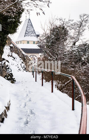 Pfad zu schneebedeckten Uhrturm Uhrturm Wahrzeichen der Stadt Graz auf Hill Schlossberg im Winter Stockfoto