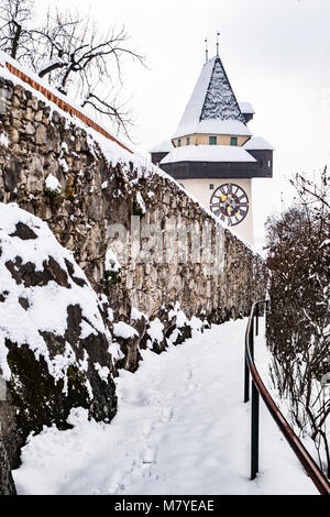 Pfad zu schneebedeckten Uhrturm Uhrturm Wahrzeichen der Stadt Graz auf Hill Schlossberg im Winter Stockfoto