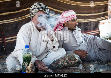 Zwei Mann rauchen eine sigaret und entspannen in Ihrem Beduinenzelt im Wadi Rum Jordanien. Stockfoto