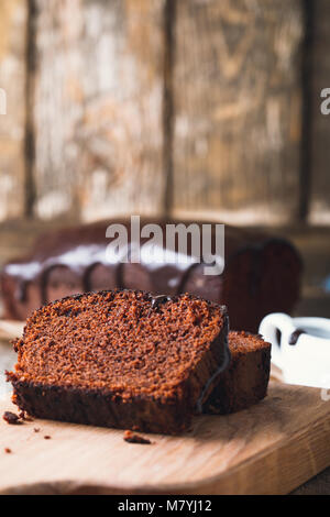 Scheiben von Schokoladenkuchen auf Holz Schneidebrett, rustikalen Stil Stockfoto