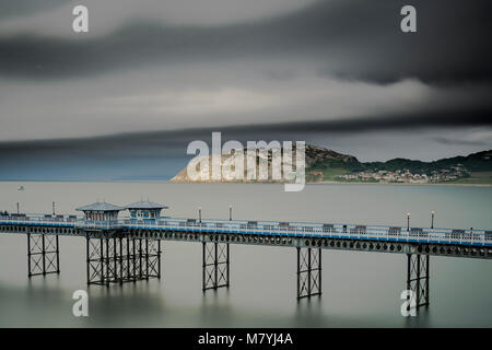 Llandudno Pier bei bewölktem Himmel an der Küste von Nordwales mit Motion Blur Auf der Himmel und das Meer Stockfoto