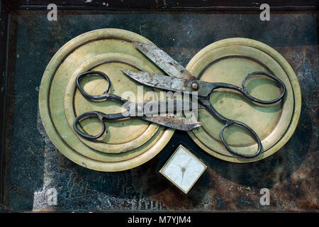 Zwei Schere auf runden Kupferplatten, Blades, square antike Wecker mit weißem Zifferblatt, original Design der Wanddekoration. Stockfoto