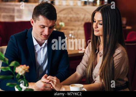 Verliebtes Paar im Restaurant halten sich an den Händen Stockfoto