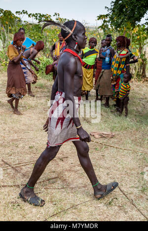 Ein Hamar Tribesman bereitet die Peitsche Junge Hamar Frauen während einer 'Erwachsen' Stier springen Zeremonie, Dimeka, Omo Valley, Äthiopien Stockfoto