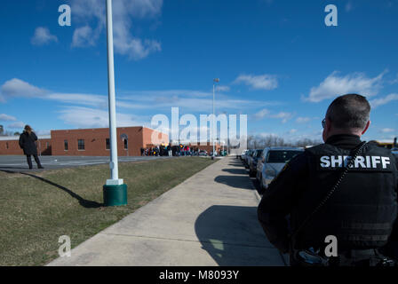 Sterling Virginia, USA. März 14, 2018: School Resource Officer Charles Gravatte hat ein Auge auf die Studenten an Seneca Ridge Middle School in Sterling Virginia, wie sie heute aus der Klasse ging an einem nationalen gehen sie aus Protest gegen die Waffengewalt zu nehmen, die nach den letzten School shooting in Florida. Der Spaziergang von student Jakob Wesoky organisiert und dauerte 17 Minuten, eine Minute für die Opfer des Amoklaufs. Credit: William Graham/Alamy leben Nachrichten Stockfoto