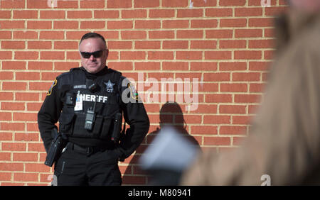 Sterling Virginia, USA. März 14, 2018: School Resource Officer Charles Gravatte hat ein Auge auf die Studenten an Seneca Ridge Middle School in Sterling Virginia, wie sie heute aus der Klasse ging an einem nationalen gehen sie aus Protest gegen die Waffengewalt zu nehmen, die nach den letzten School shooting in Florida. Der Spaziergang von student Jakob Wesoky organisiert und dauerte 17 Minuten, eine Minute für die Opfer des Amoklaufs. Credit: William Graham/Alamy leben Nachrichten Stockfoto