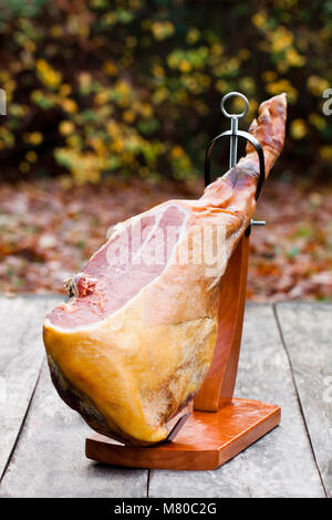 Ganze jamon auf einem Stand aus Holz auf Holz- Tabelle Stockfoto