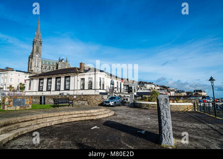 Cobh, Irland - 9 November, 2017: Waterfront und der Promenade in Cobh mit St. Colman Kathedrale im Hintergrund ein sonniger Morgen mit blauem Himmel. Cobh ist ein p Stockfoto