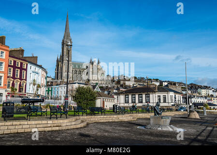 Cobh, Irland - 9 November, 2017: Waterfront und der Promenade in Cobh mit St. Colman Kathedrale im Hintergrund ein sonniger Morgen mit blauem Himmel. Cobh ist ein p Stockfoto