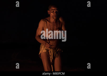 Ein San Buschmänner erzählt eine Geschichte rund um ein Feuer in Ghanzi, Botswana. Stockfoto