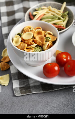 Zwei Arten rohe Nudeln in kleine Schüssel, Lebensmittel Nahaufnahme Stockfoto