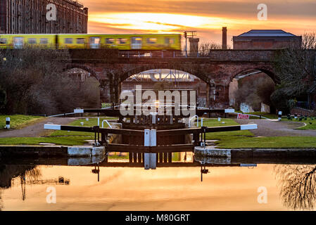 Merseyrail elektrische Zug Überfahren der Leeds Liverpool Canal Locks in Stanley Dock. Abendlicht. Sonnenuntergang Stockfoto