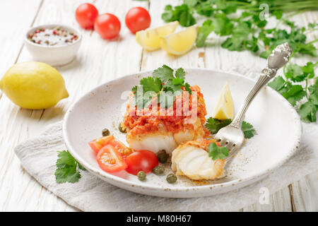 Weißer Fisch (Kabeljau, Seelachs, nototenia, Seehecht), geschmorte Zwiebeln, Karotten und Tomaten. Gemüse Marinade. Köstliche warme und kalte Snacks für Feinschmecker. S Stockfoto