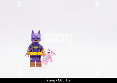 Lego batgirl Holding rosa Teddybär. auf weißem Hintergrund. Stockfoto