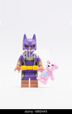 Lego batgirl Holding rosa Teddybär. auf weißem Hintergrund. Stockfoto