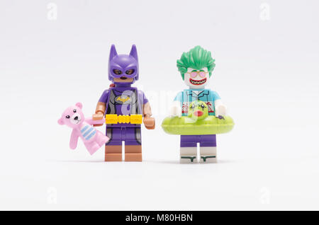 Lego batgirl Holding Teddybär mit Joker Minifigur, auf weißem Hintergrund. Stockfoto