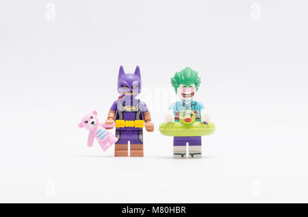 Lego batgirl Holding Teddybär mit Joker Minifigur, auf weißem Hintergrund. Stockfoto