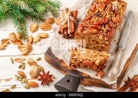 Festliche hausgemachte Urlaub Obstkuchen mit Nüssen, Früchten und Gewürzen. Mandeln, Zimt, Sternanis, Kardamom auf dem Tisch. Weihnachten. Für das neue Jahr. Selektive f Stockfoto