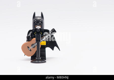 "Lego Batman" singen und spielen eine Gitarre auf weißem Hintergrund. Stockfoto