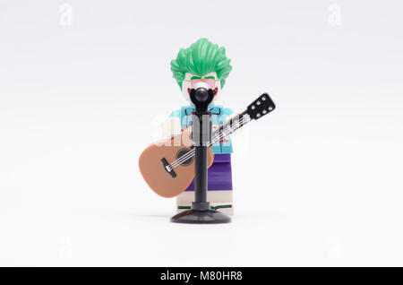 Lego joker Figur Holding eine Gitarre mit Mikrofon auf weißem Hintergrund. Stockfoto