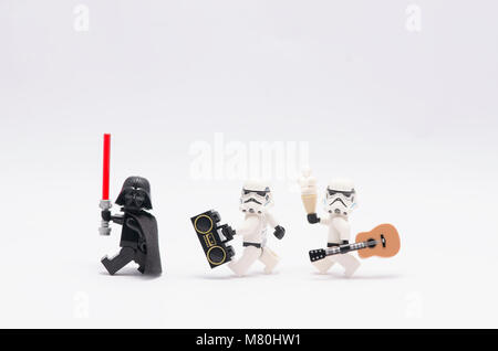 Lego Darth Vader holding Lichtschwert mit Storm troopers Holding ein Radio und eine Gitarre. auf weißem Hintergrund. Stockfoto