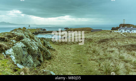 UK, Anglesey, Rhosneigr, 11. März 2018. Ein Blick entlang Llanddwyn Island mit Blick auf Twr Mawr, Twr Bach Leuchttürme und der Pilot Cottages. Stockfoto