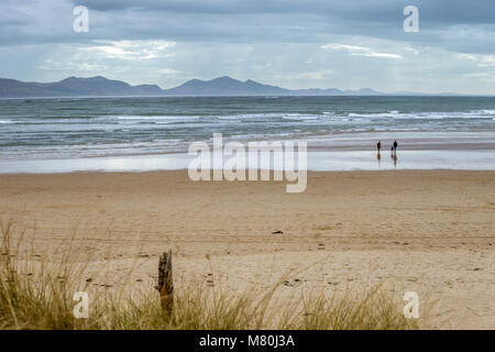 UK, Anglesey, Rhosneigr, 11. März 2018. Ein Blick auf llanddwyn Beach mit dem Snowdonia Mountains im Hintergrund. Stockfoto