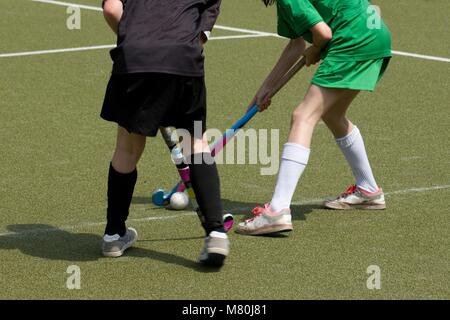 Zwei Mädchen spielen Hockey auf Kunstrasen Feld Stockfoto