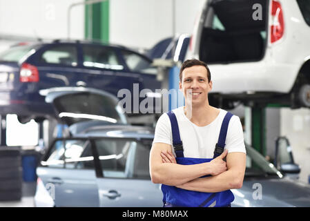 Portrait Mitarbeiter/Mechaniker in der Garage - lächelnder Mann in Arbeitskleidung Stockfoto