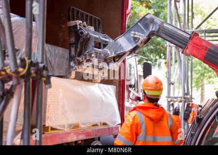 Arbeiter Be- oder Entladen ein Vorhang zur Seite LKW-Ladung mit einem Gabelstapler Stockfoto