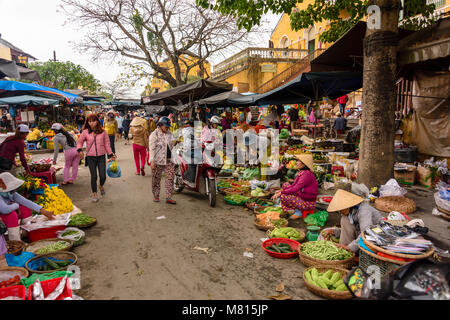 Frauen verkaufen Gemüse auf der Straße vor der Markthalle in Hoi An, Vietnam Stockfoto