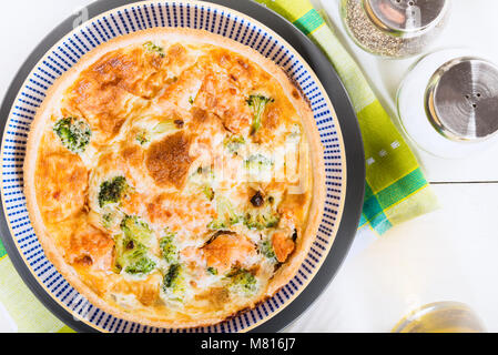 Klassische Lachs und Broccoli Quiche aus mürbteig Gebäck mit Brokkoliröschen und geräuchertem Lachs in einer cremigen freie Strecke Eierstich Stockfoto
