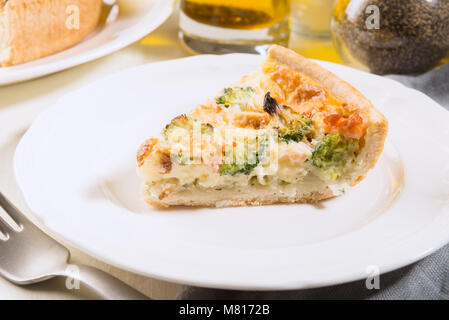 Klassische Lachs und Broccoli Quiche aus mürbteig Gebäck mit Brokkoliröschen und geräuchertem Lachs in einer cremigen freie Strecke Eierstich Stockfoto