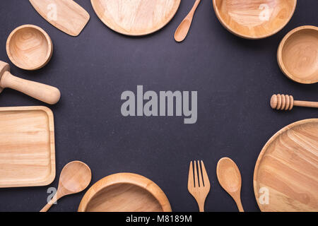 Sammlung von neuen Holz- küchenutensil, Schale, Teller, Löffel, Teller. Studio Schuß auf Schwarzen Tisch Hintergrund. Mit Freiraum für Text oder Design Stockfoto