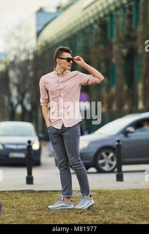 Junge zu Fuß auf der Straße der Stadt und eine Schutzbrille lächeln in die Kamera Stockfoto