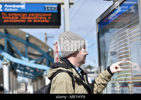 Pkw suchen unter Fahrplan auf einer russischen S-Bahnhof Stockfoto