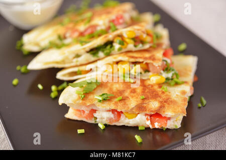 Vegetarische quesadilla mit saurer Sahne. Selektiver Fokus auf der Vorderseite Keil Stockfoto