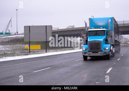 Big Rig blue Classic American Semi Truck mit aerodynamischen Teil der Räuber fallen Textil Dry van Auflieger und hohe auspuffrohre bewegt sich m Stockfoto