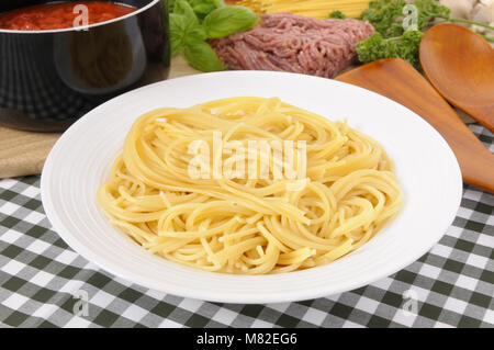 Schüssel Spaghetti mit Bolognese Sauce und Zutaten in den Hintergrund. Stockfoto